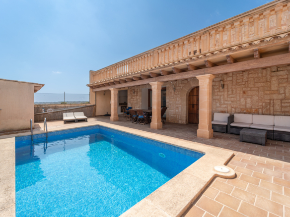 Casa de campo en alquiler en Ses Salines con piscina privada, porche de columnas y fachada de marés.