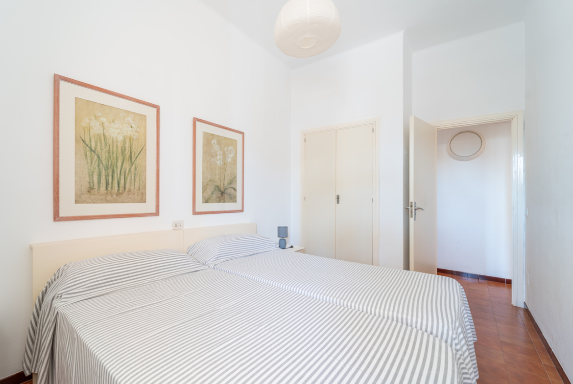 Dormitorio con cama doble, cuadros enmarcados y armario.