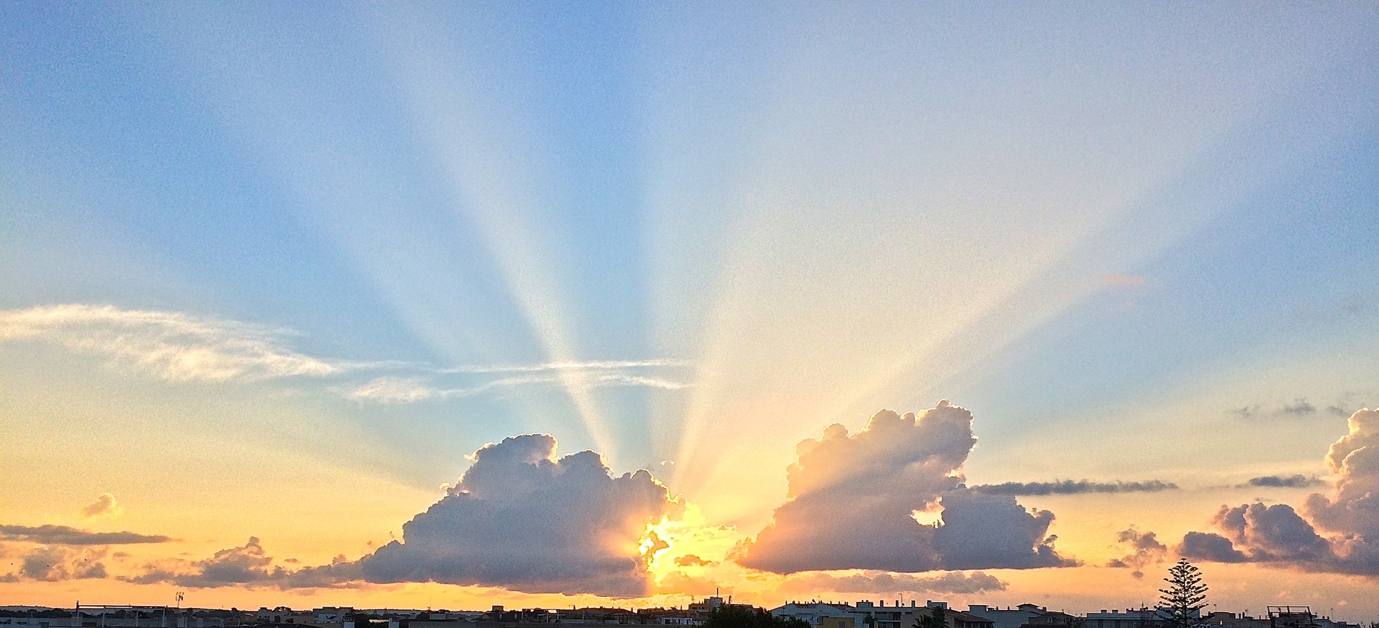 Amanecer con rayos de sol entre nubes sobre la Colònia de Sant Jordi, Mallorca